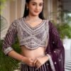 Full-length shot of a woman in a deep purple Sider Lehenga with heavy silver embroidery, standing in a hallway with a chevron floor.